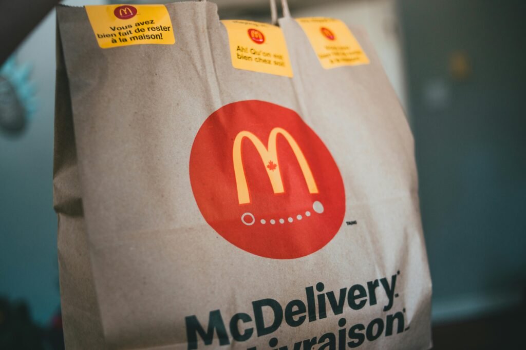 Close-up of a McDelivery brown paper bag with vivid logo and text.